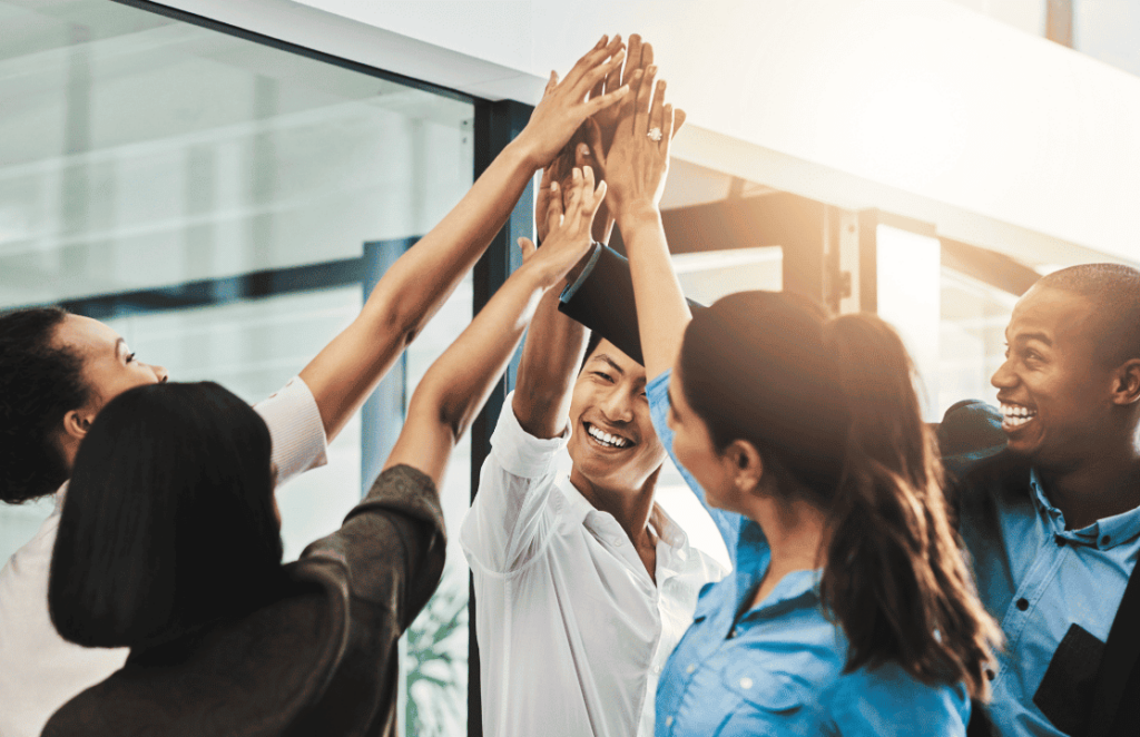 A group of business people giving each other high fives.